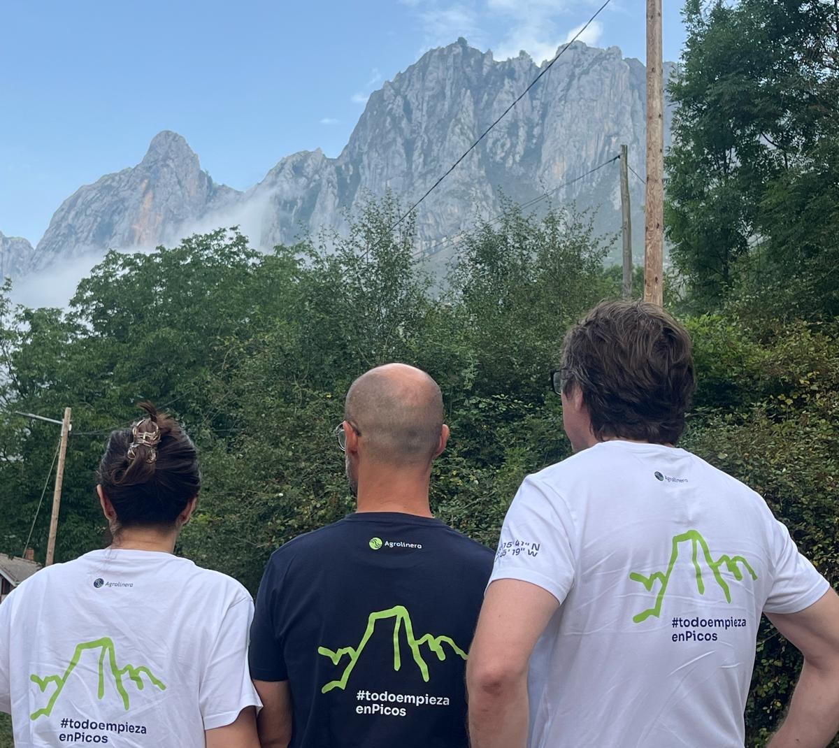 Equipo de Agrolinera de espaldas frente a Picos de Europa con camisetas #todoempiezaenPicos